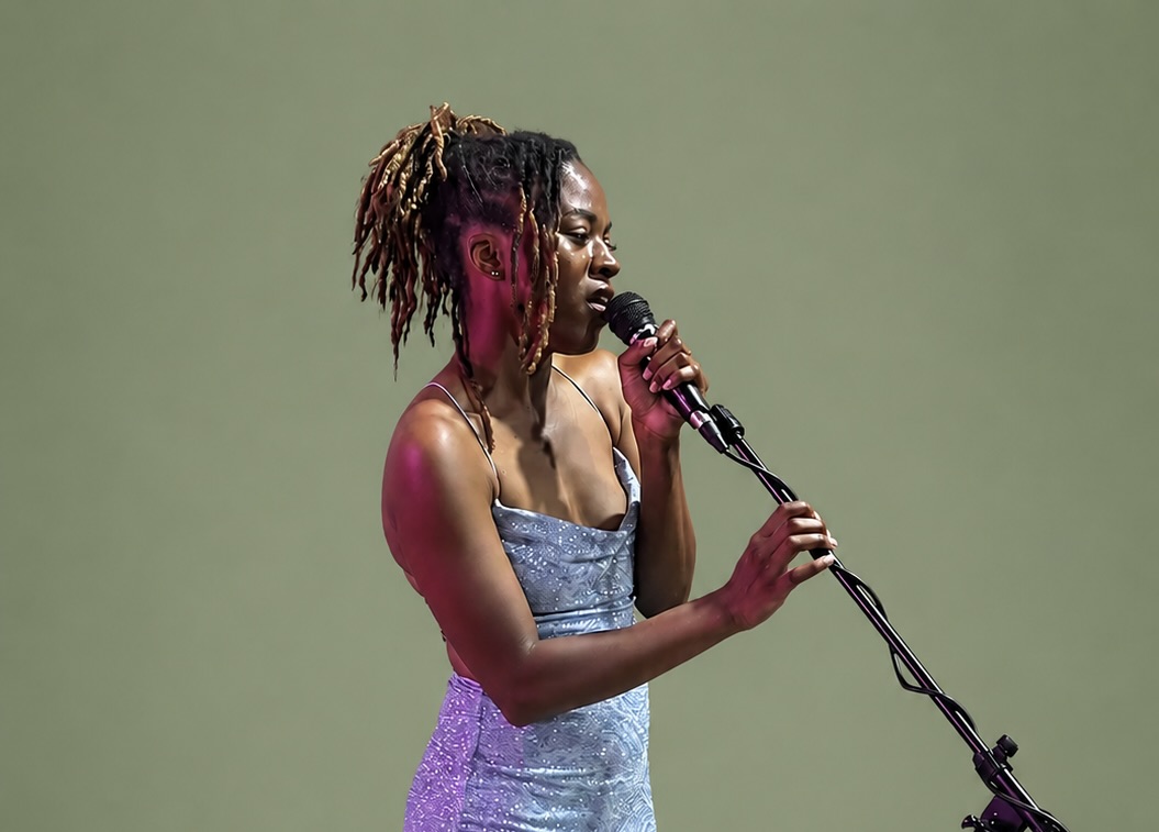 Vocalist singing into a microphone on stage